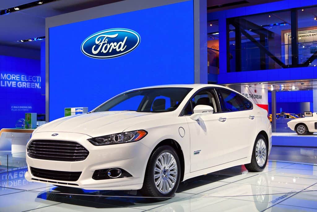 A white Ford Fusion displayed at a car show