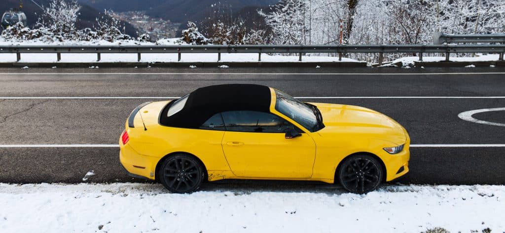 A yellow Ford Mustang is parked on the side of the road. Russia, Sochi