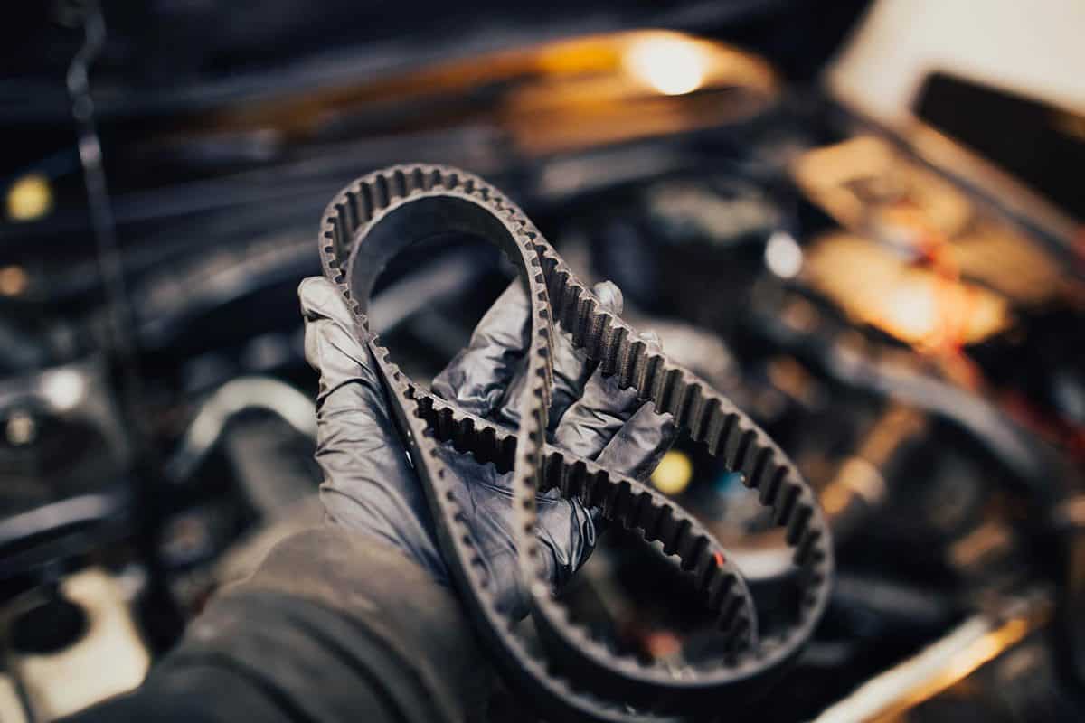 Automotive timing belt in the hand of an auto mechanic