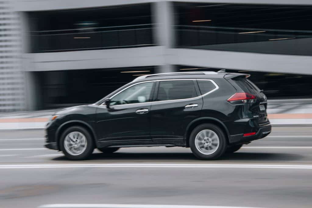 Black Nissan Rogue car moving on the street