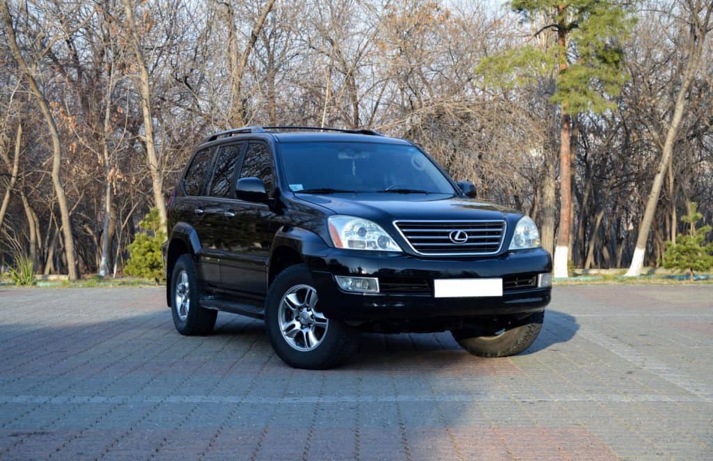 Black obsidian black suv Lexus GX in the middle of city park's car parking