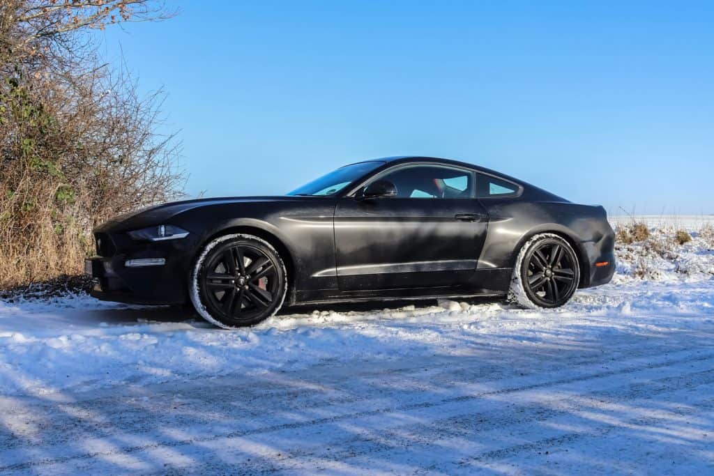 Black sports car in front of a winter landscape in Germany