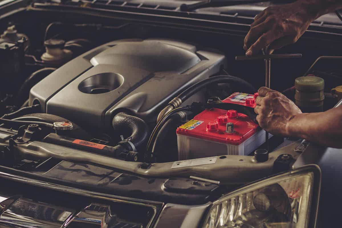 Car service fitting a car battery with wrench