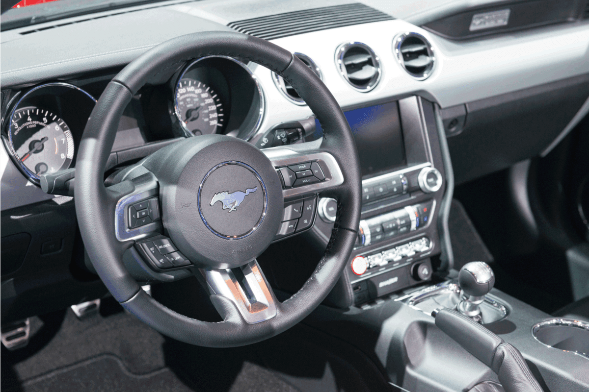 Dashboard on a red 2016 5.0L V8 Ford Mustang GT Premium Convertible Muscle Car. The car is on display during a Motor Show