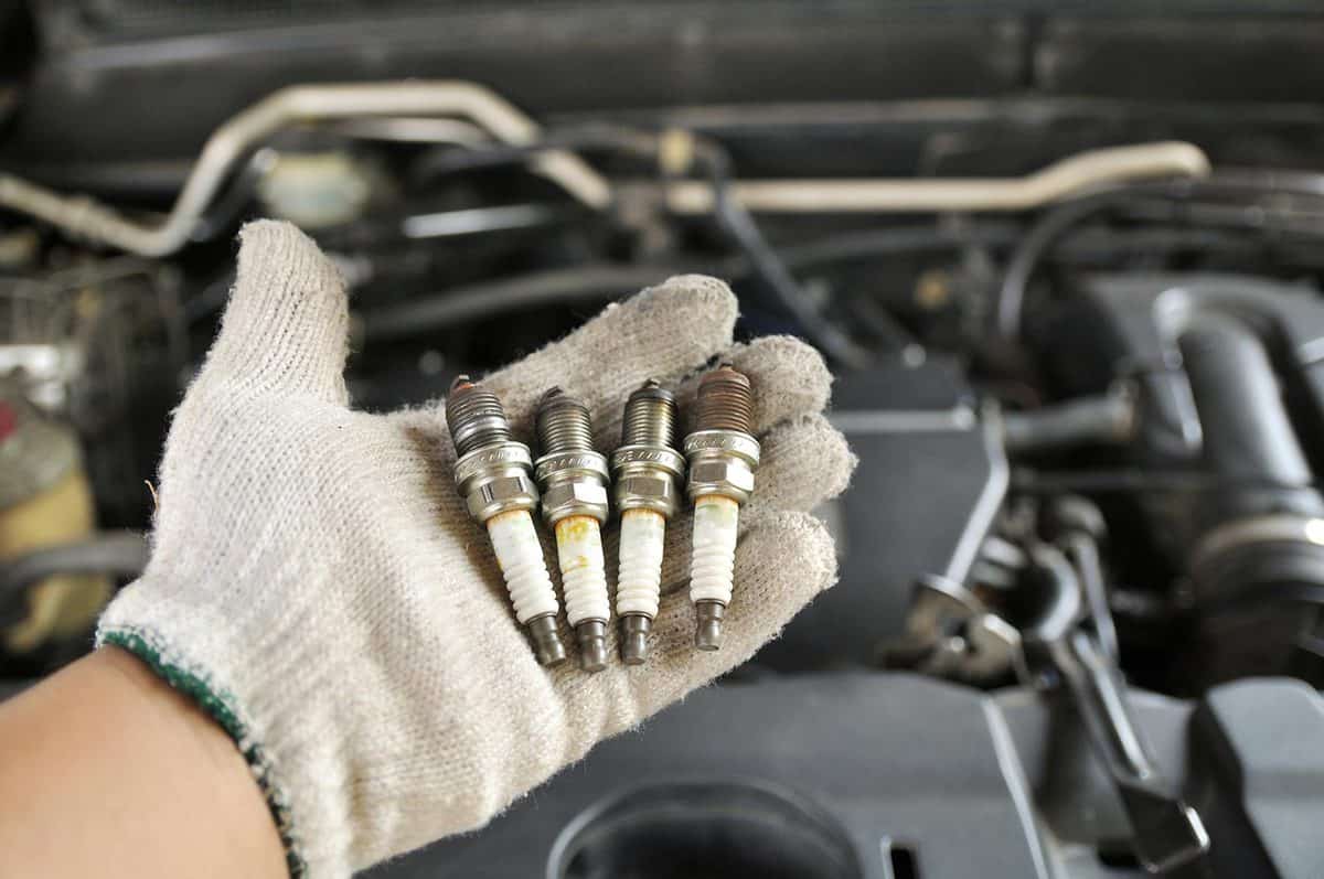 Dirty old spark plugs on the hand of the mechanic