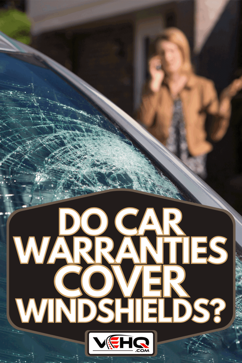 A woman phoning for help after car windshield has broken, Do Car Warranties Cover Windshields?