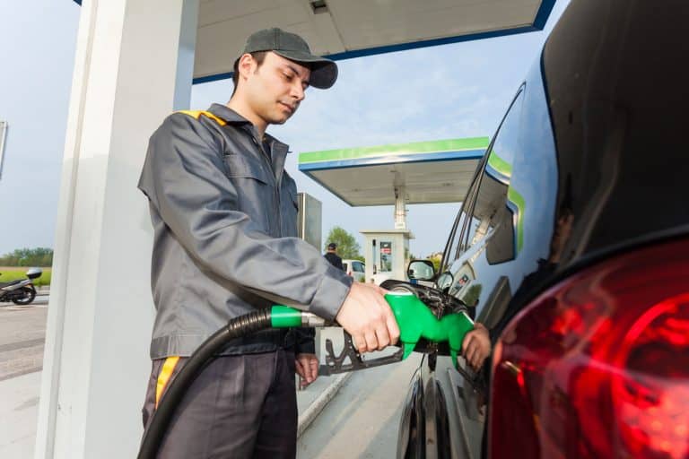 Gas station assistant refueling a car, Does The Buick Envision Take Regular or Premium Gas?