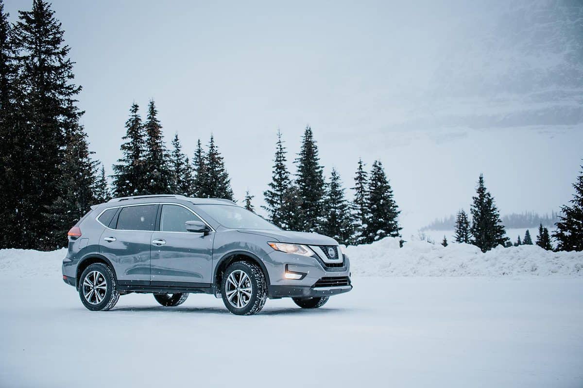 Grey Nissan Rogue parked amidst snowy winter scene