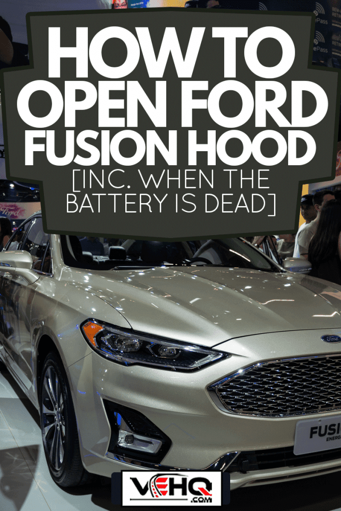 A light beige Ford Fusion Energi (American plug-in hybrid 4-door midsize sedan - 2nd Gen) displayed inside Ford pavilion, How To Open Ford Fusion Hood [Inc. When The Battery Is Dead]