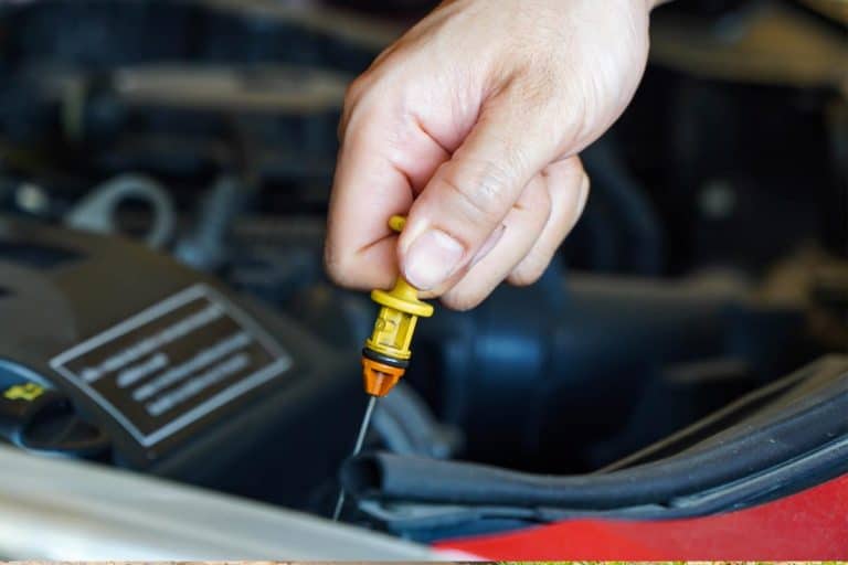 Mechanic checking the level of oil in a car, How To Check Transmission Fluid For The Honda Accord
