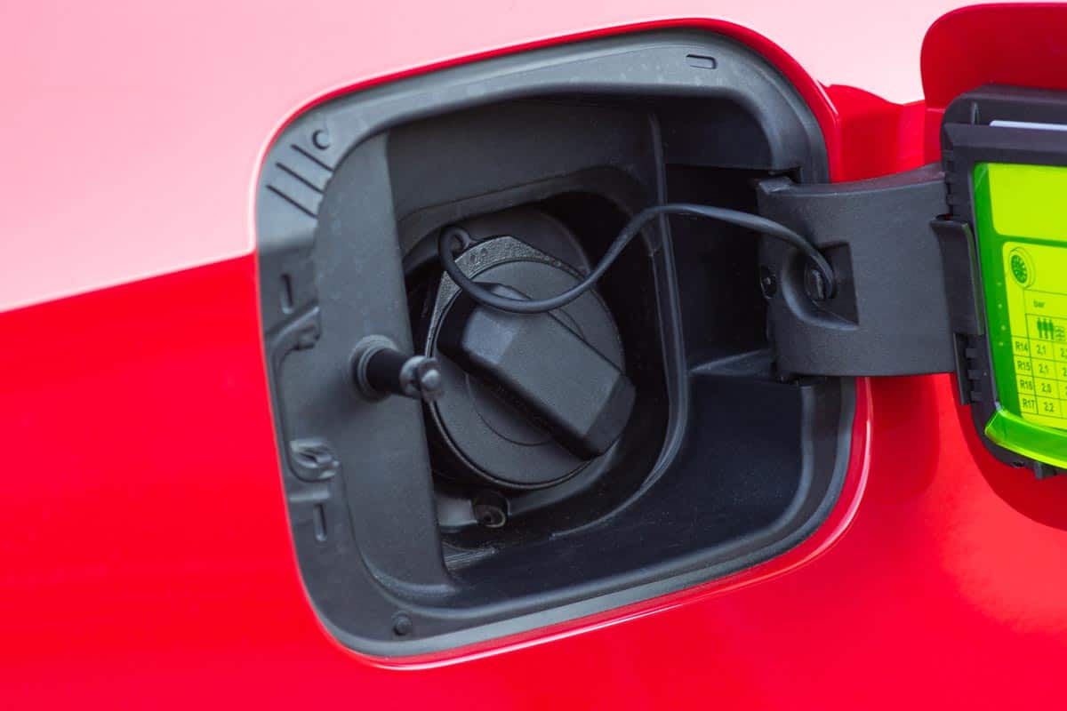 A photo of an open red car gas tank, How To Open The Gas Tank Of A Nissan Rogue
