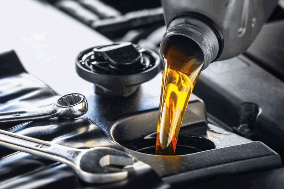 Pouring motor oil for motor vehicles from a gray bottle into the engine, oil change, auto repair shop, service