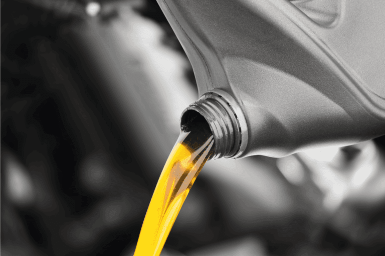 Pouring oil lubricant motor car from black bottle on isolated white background. What's The Best Oil For Kia Seltos