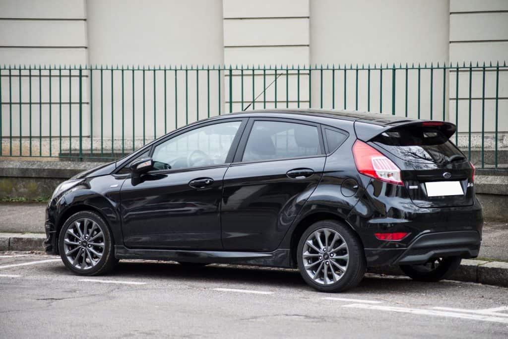 Rear view of black Ford fiesta parked in the street