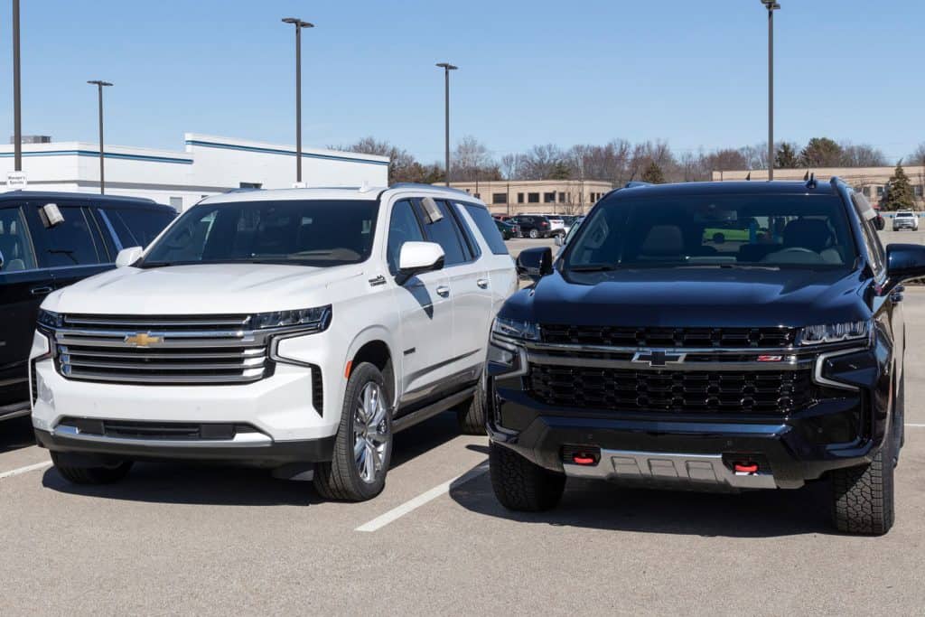 Two different trims of Chevrolet Suburbans at a dealership