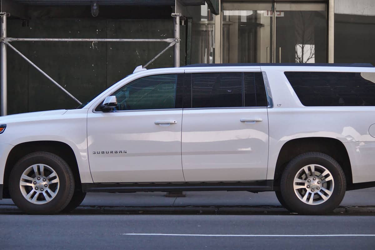 White and shiny luxury SUV, Chevrolet Suburban on the street of New York, How Big Is The Gas Tank On A Chevy Suburban?