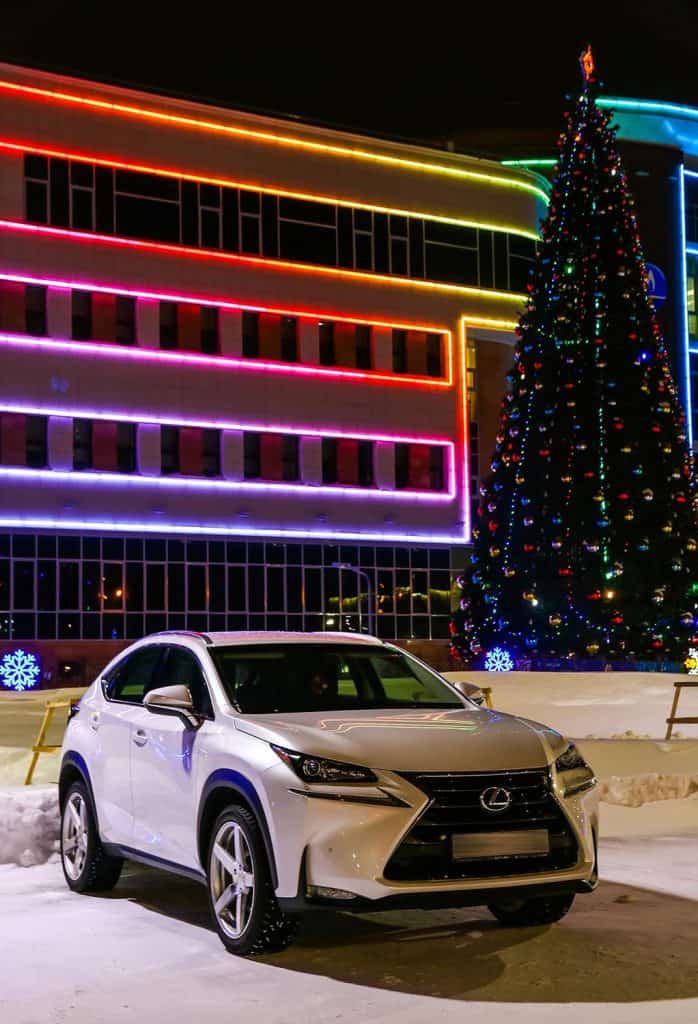 White crossover Lexus NX at the background of a Christmas tree
