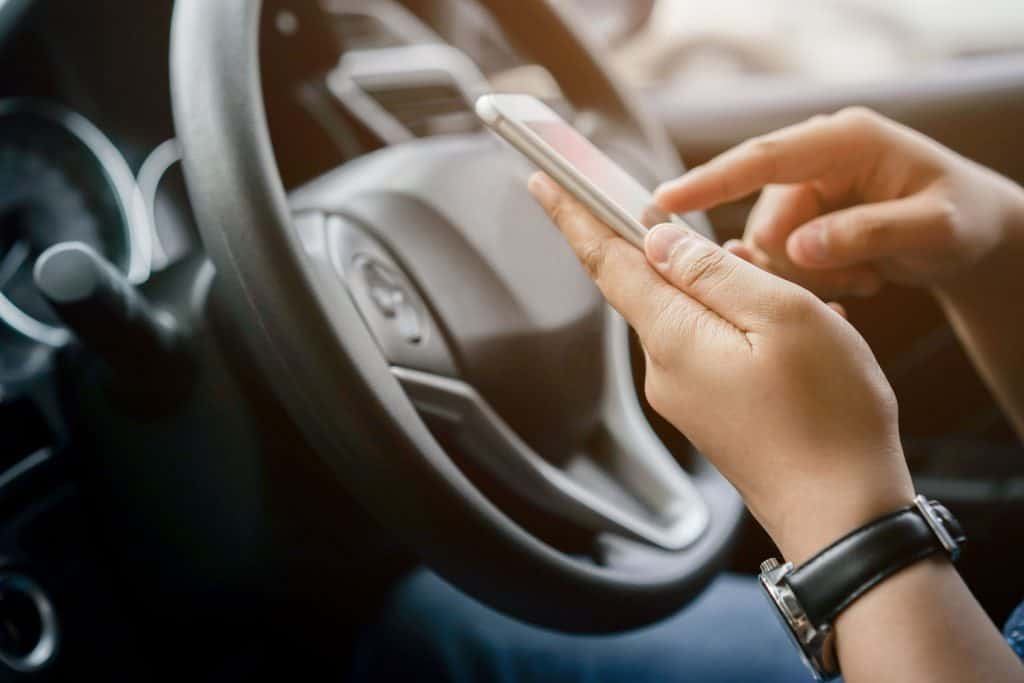 close up driver woman hand holding smartphone for using GPS navigation of travel destination