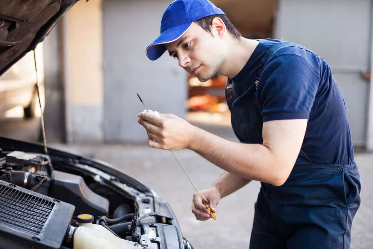 mechanic checking oil level car engine