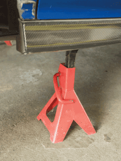 red-car-jack-stand-underneath-a-car-for-repair.-Does-Every-Car-Come-With-A-Jack