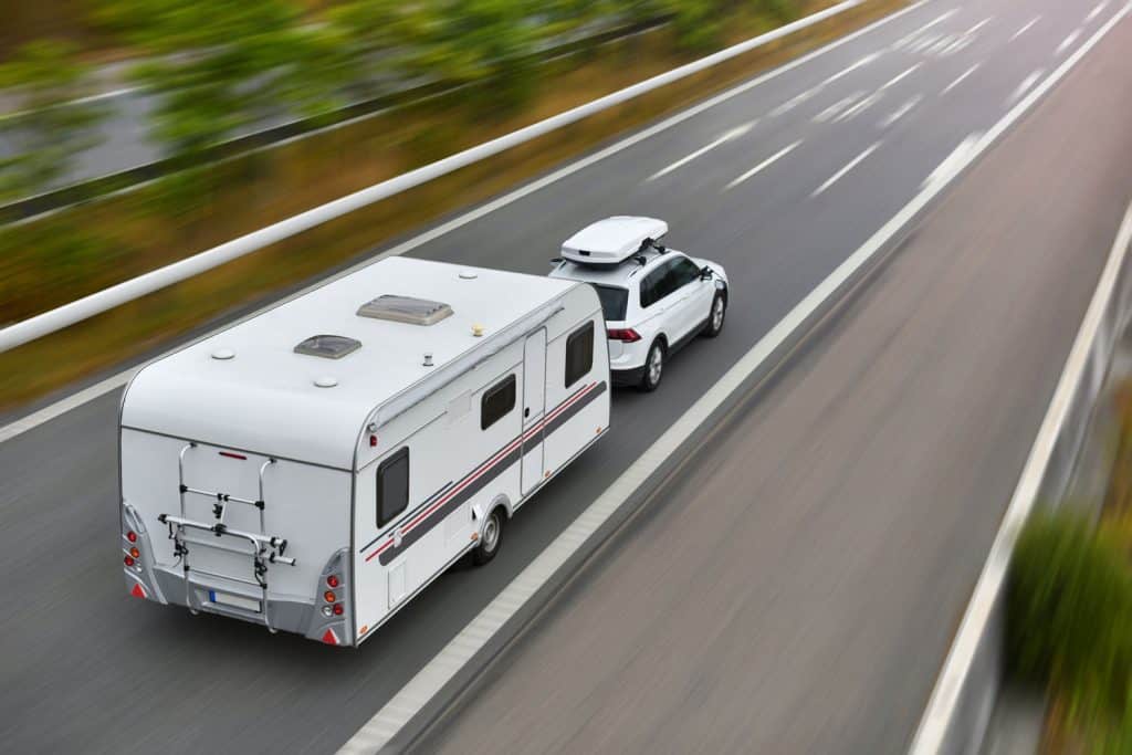travel on car with caravan trailer by highway