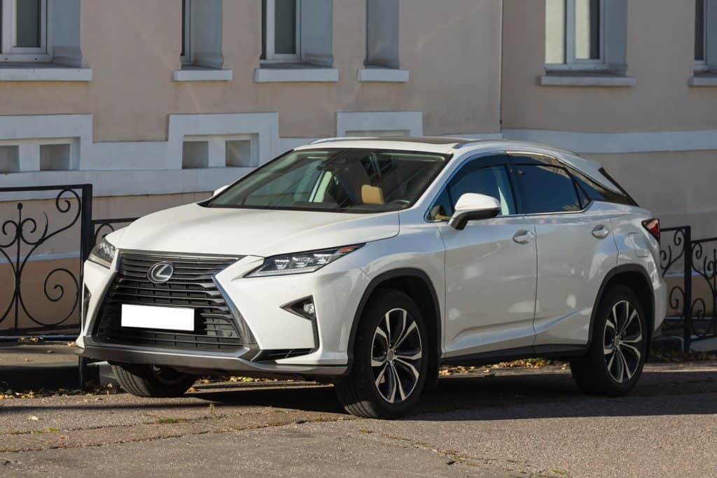 white Lexus RX350 is parked on the street on a warm autumn day