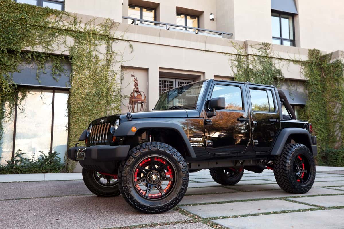 A Jeep Wrangler parked in front of a building