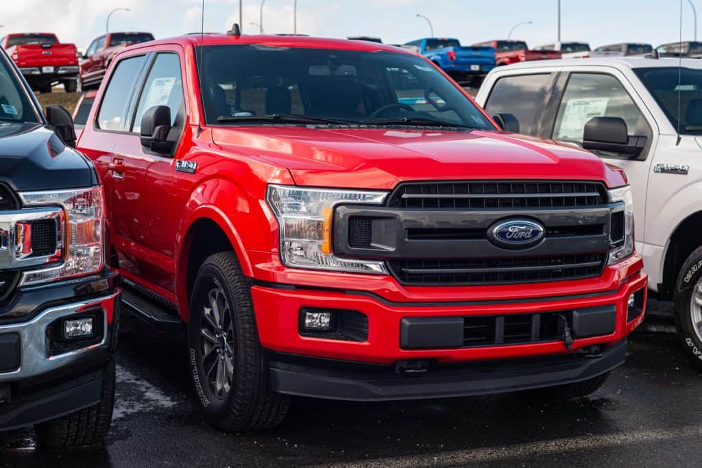 A red colored Ford F150 at the parking lot