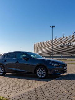 A black Mazda 3 on the parking lot at a huge stadium, Why Is My Mazda 3 Beeping?