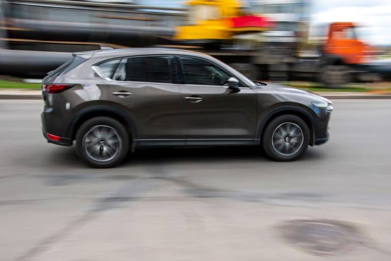 A brown 2021 Mazda CX-5 moving on the road, How Many Suitcases Fit In A Mazda CX-5?