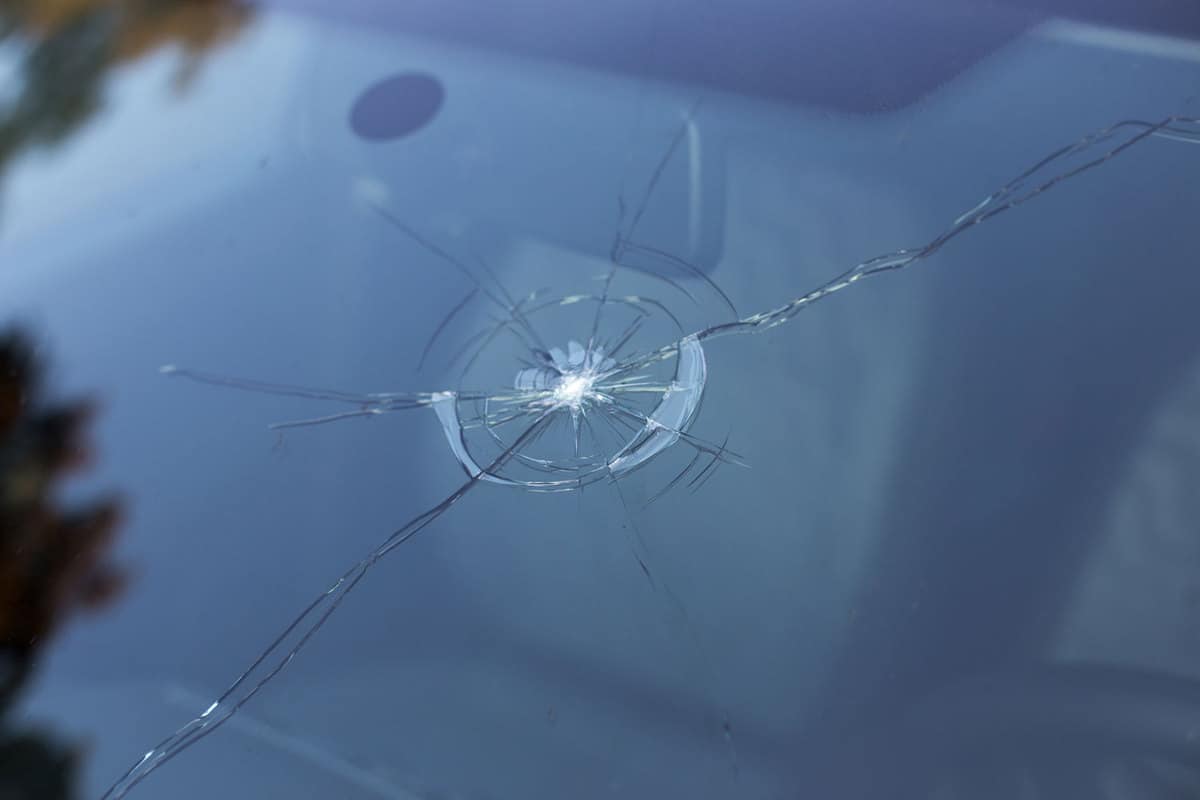 A cracked windshield caused by highway debris