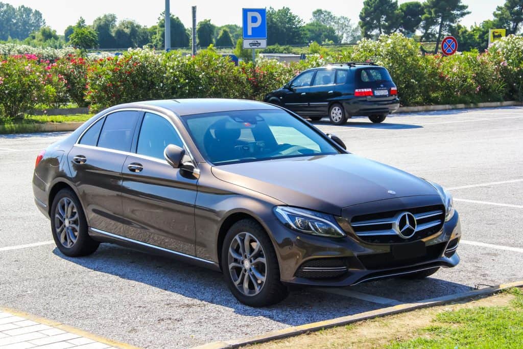 A dark brown colored Mercedes Benz C class at a parking lot
