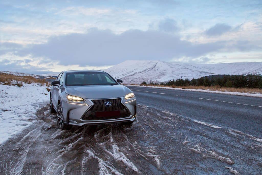 A gray Lexus RX parked on the side of a slippery road