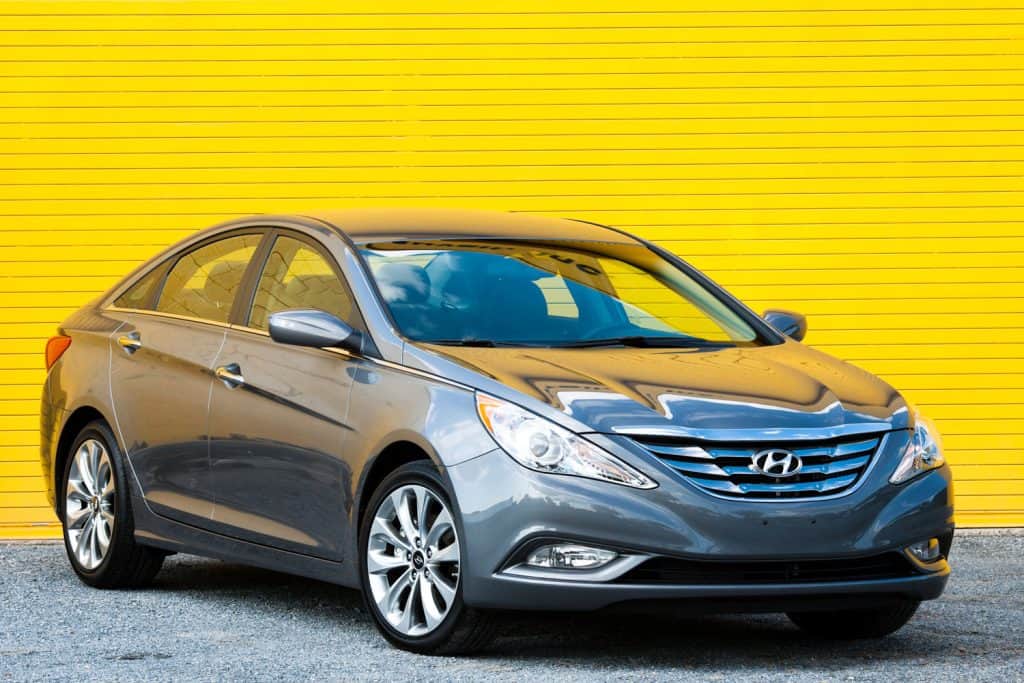 A new, gray Hyundai Sonata SE 2.0 Turbo sedan parked in front of a yellow roll-up door, How Much Does A Hyundai Sonata Weigh?