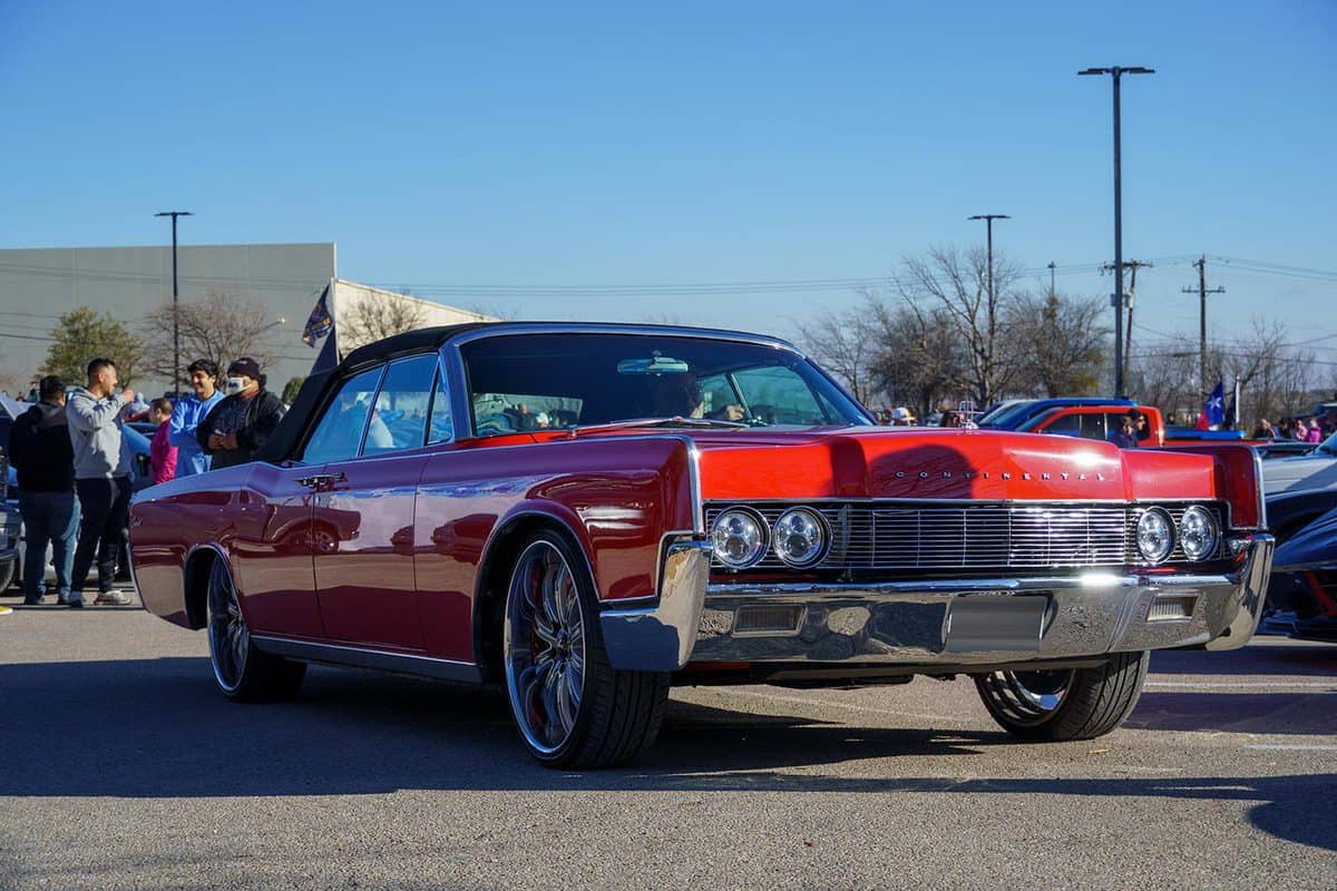 A red Lincoln Continental backing into a parking space at a car show in Austin Texas