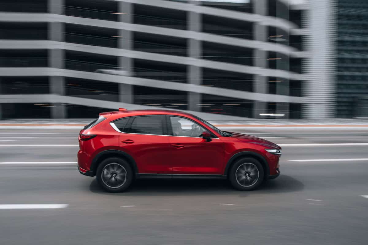 A red Mazda CX-5 moving on the city highway