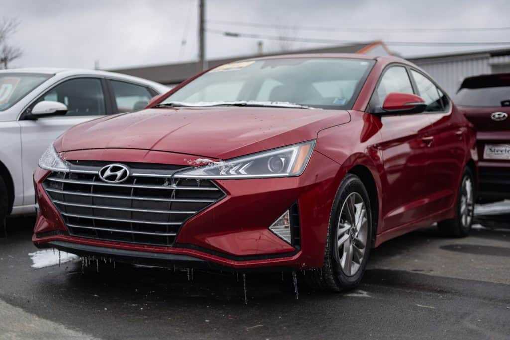 A red colored Hyundai Sonata at the dealership with icicles forming on the bumper