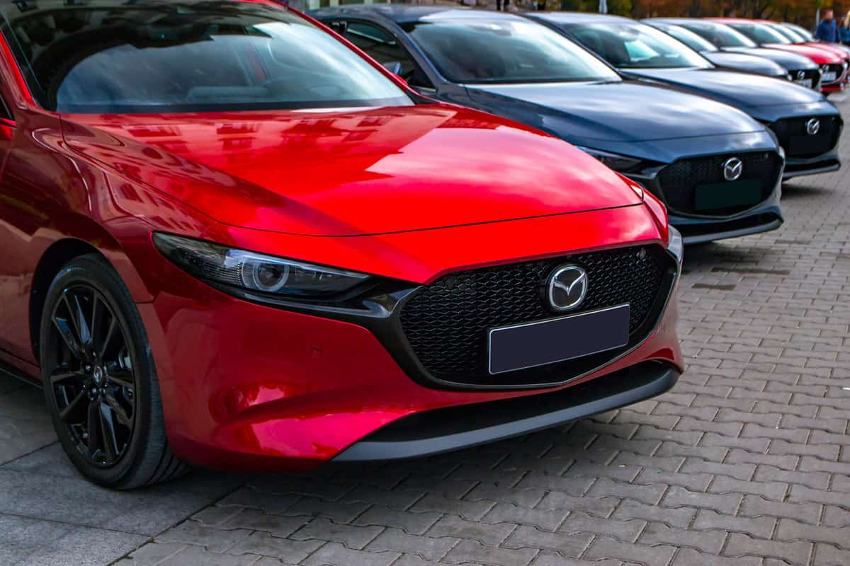 A series of different colored Mazda 3s at a dealership