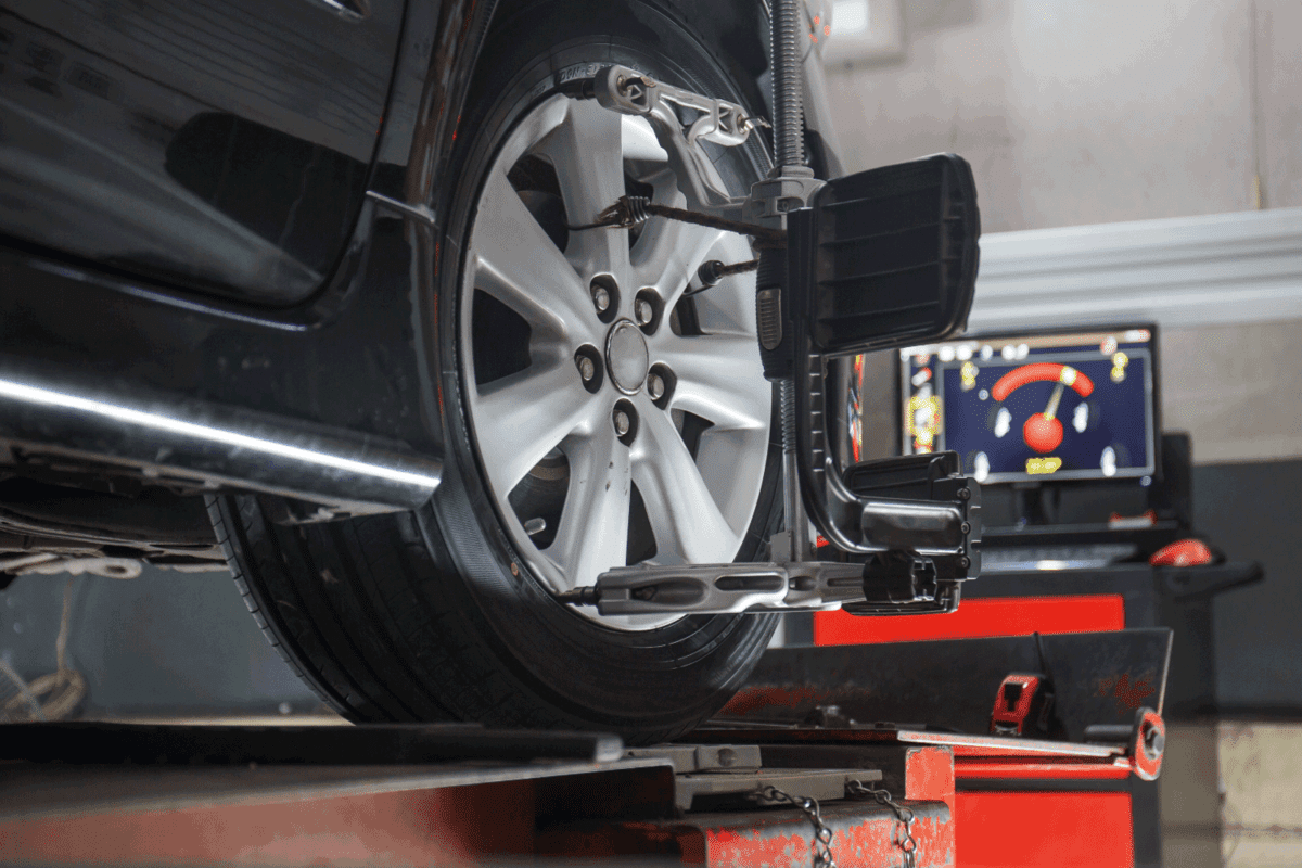 Car on stand with sensors on wheels for wheels alignment camber check