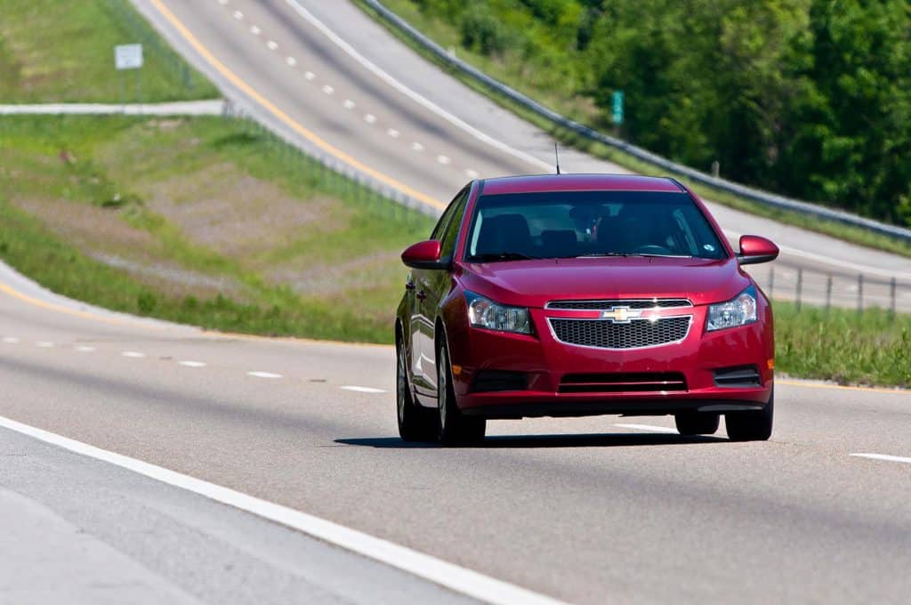 Chevrolet Malibu changes lanes on interstate highway