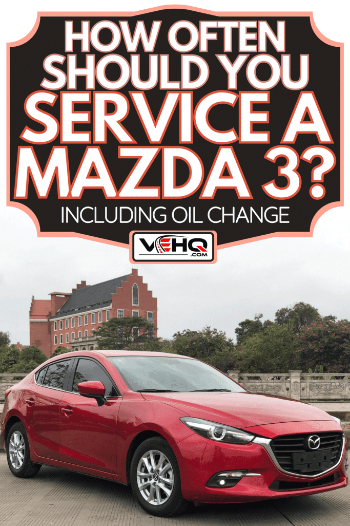 Mazda 3 park on the street with beutiful orange building in the back, How Often Should You Service A Mazda 3? [Inc. Oil Change]