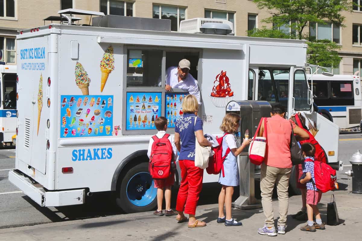 Ice cream man giving ice cream trucks to his customers