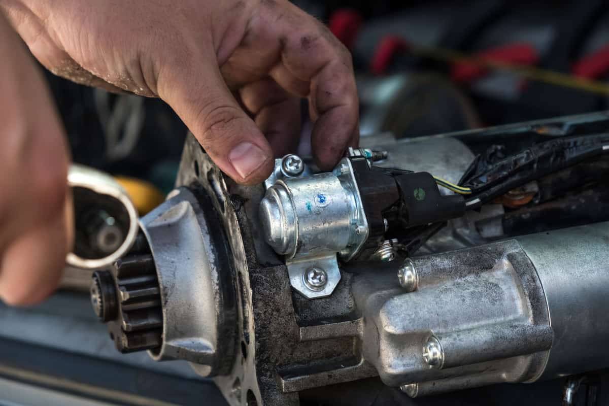 Mechanics with dirty hands repair broken starter on car Automotive service
