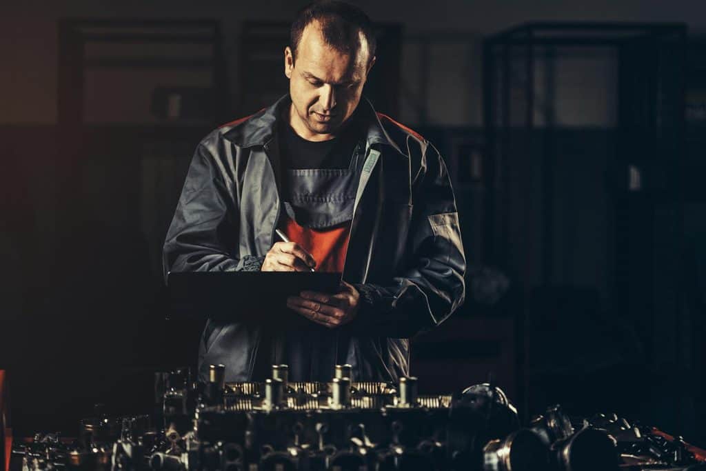 Professional car mechanic repairing V8 engine in auto repair shop