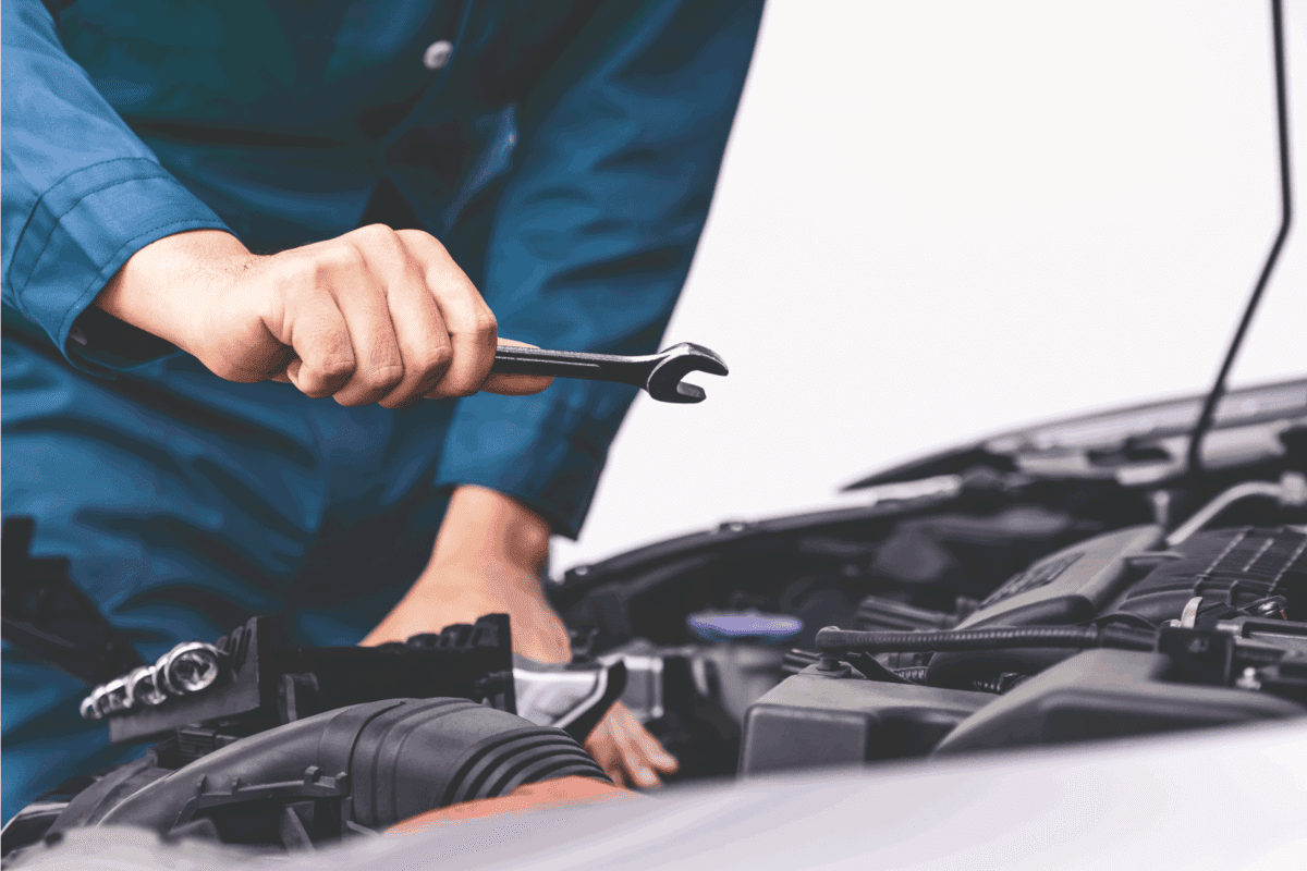 Professional mechanic hand providing car repair and maintenance service in auto garage