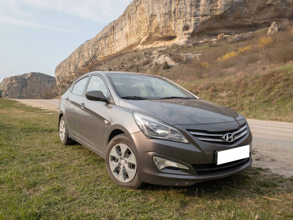 The car Hyundai Solaris is parked in nature. 