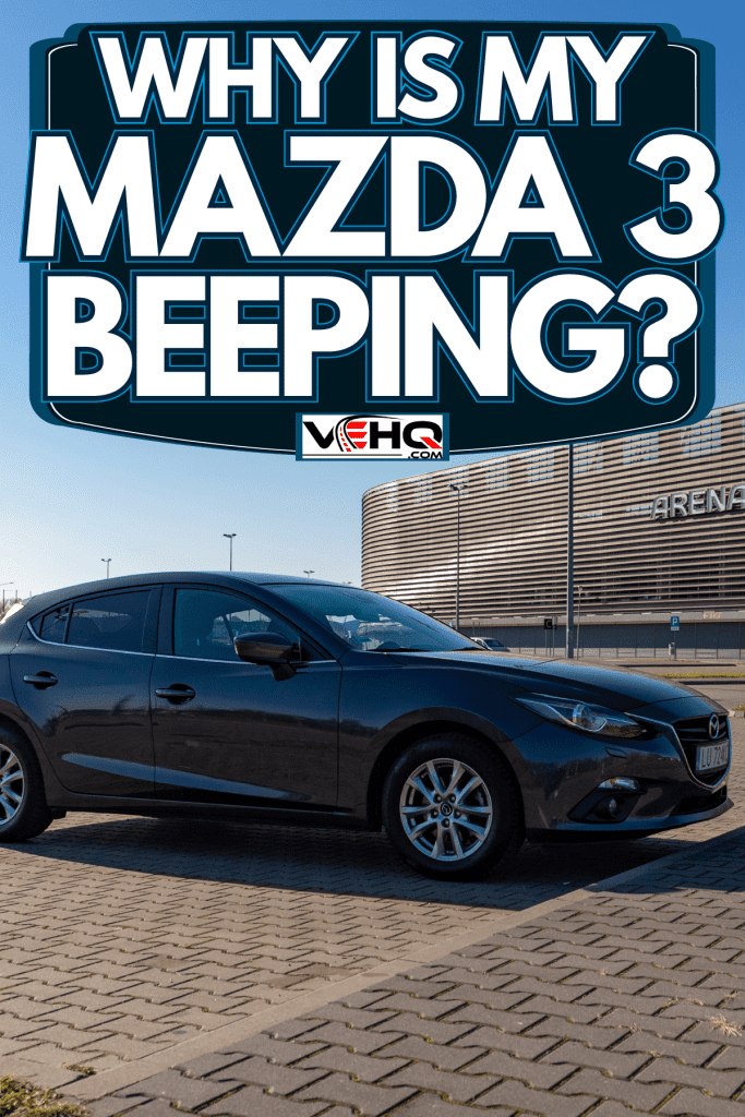 A black Mazda 3 on the parking lot at a huge stadium, Why Is My Mazda 3 Beeping?