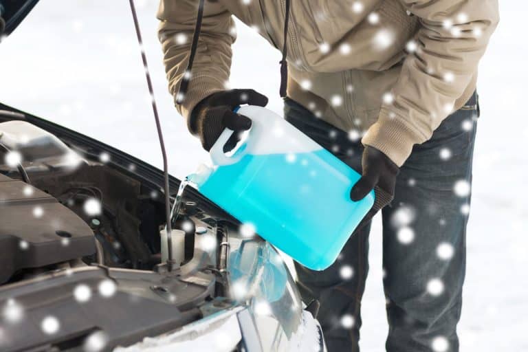 transportation, winter, people and vehicle concept - closeup of man pouring antifreeze into car, How Often to Change Antifreeze [By Vehicle Brand]