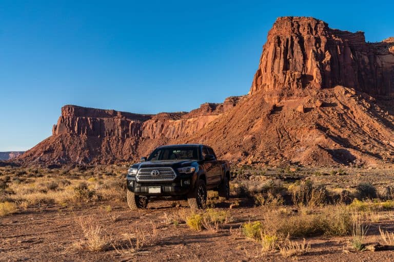 A black colored Toyota Tacoma cruising on the monument stones of Arizona, Toyota Tacoma SR Vs SR5 - Which Is Right For You?