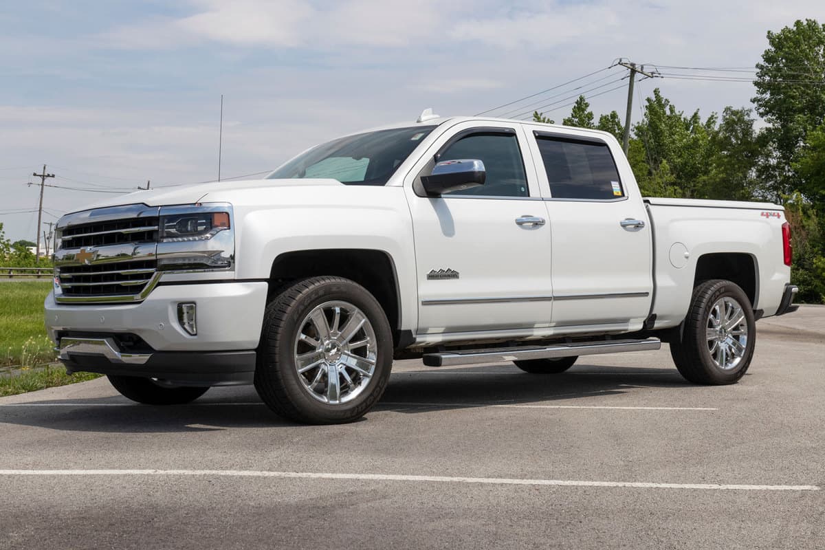 A huge white Chevrolet Silverado 1500 parked or displayed at a dealership